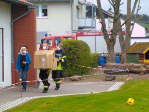 Die Helfer der Feuerwehr bringen mit dem Feuerwehrauto Geschenke